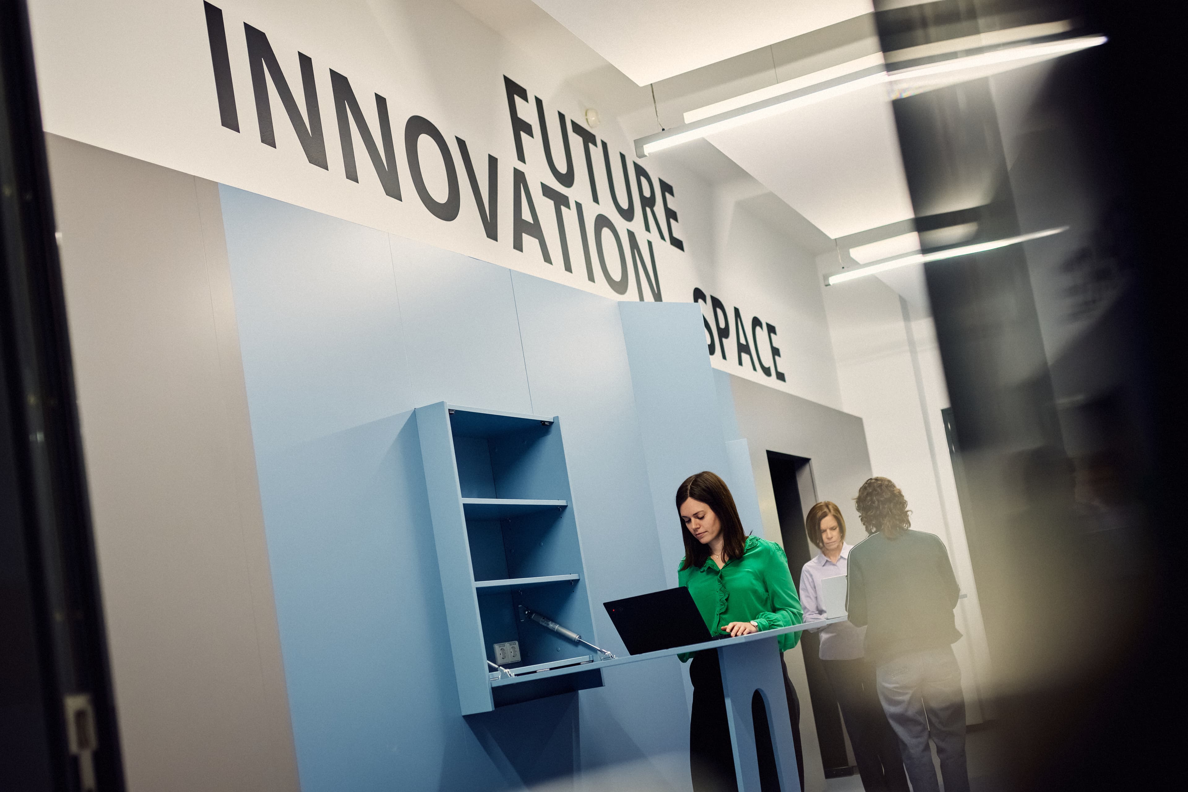 Three IWM employees working in front of the Future Innovation Space