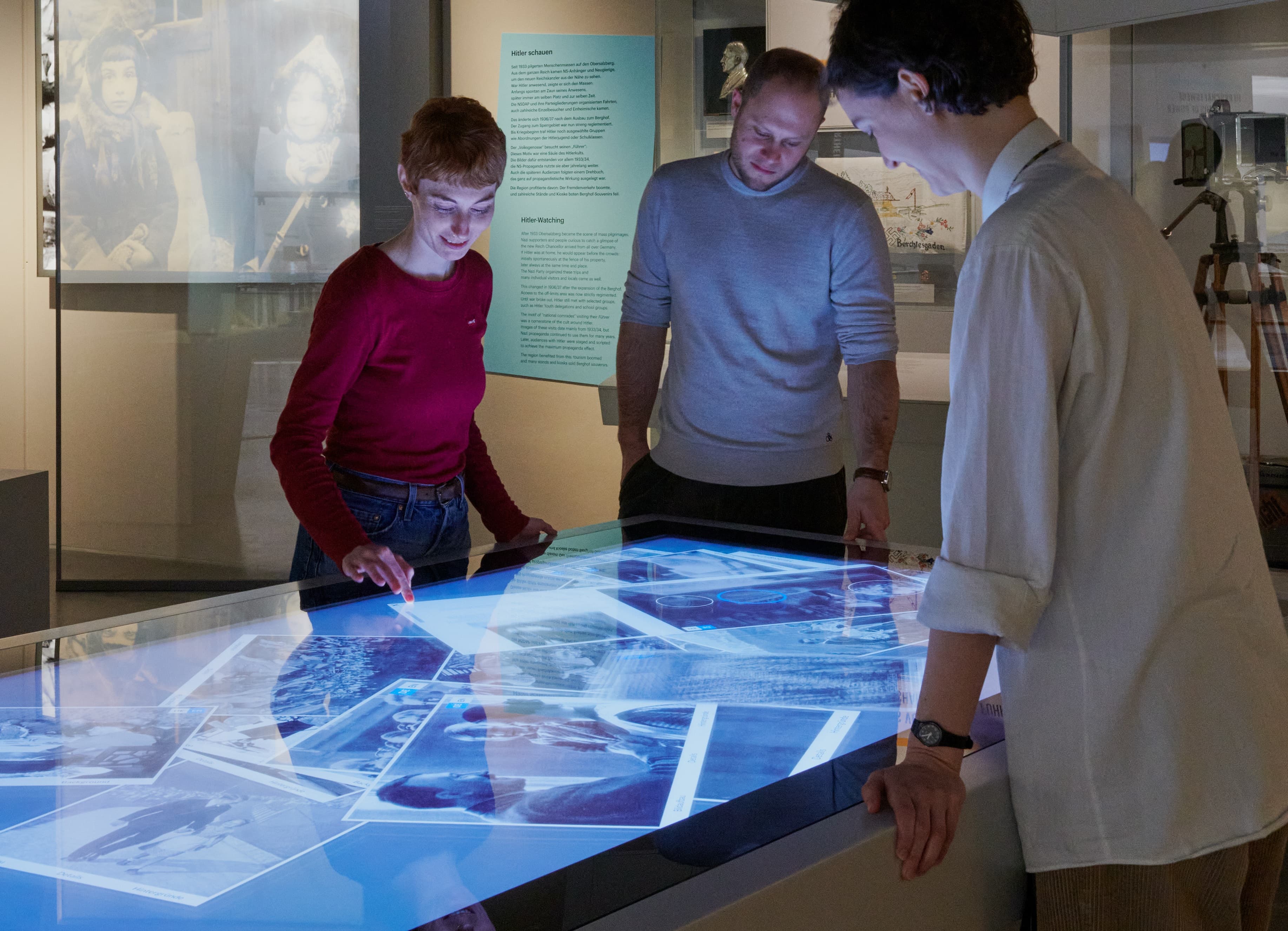 Menschen um einen Multi-Touch-Tisch stehend, beim Wischen