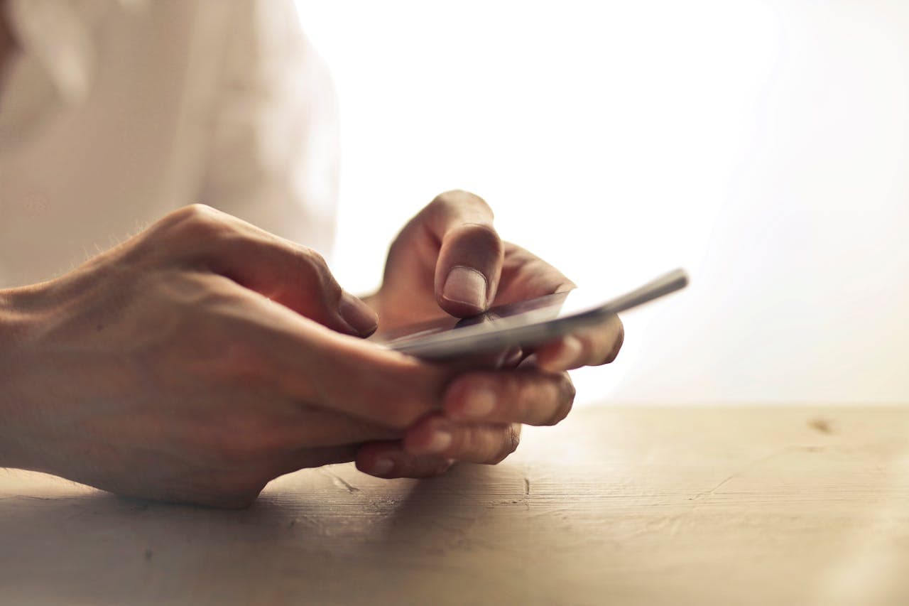Hände, die auf einem Smartphone tippen