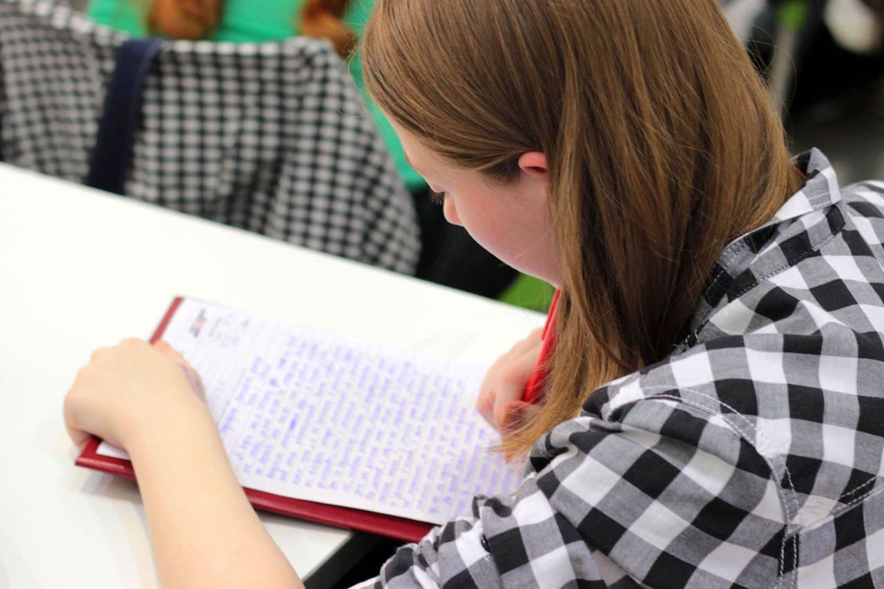 A pupil writes something on paper