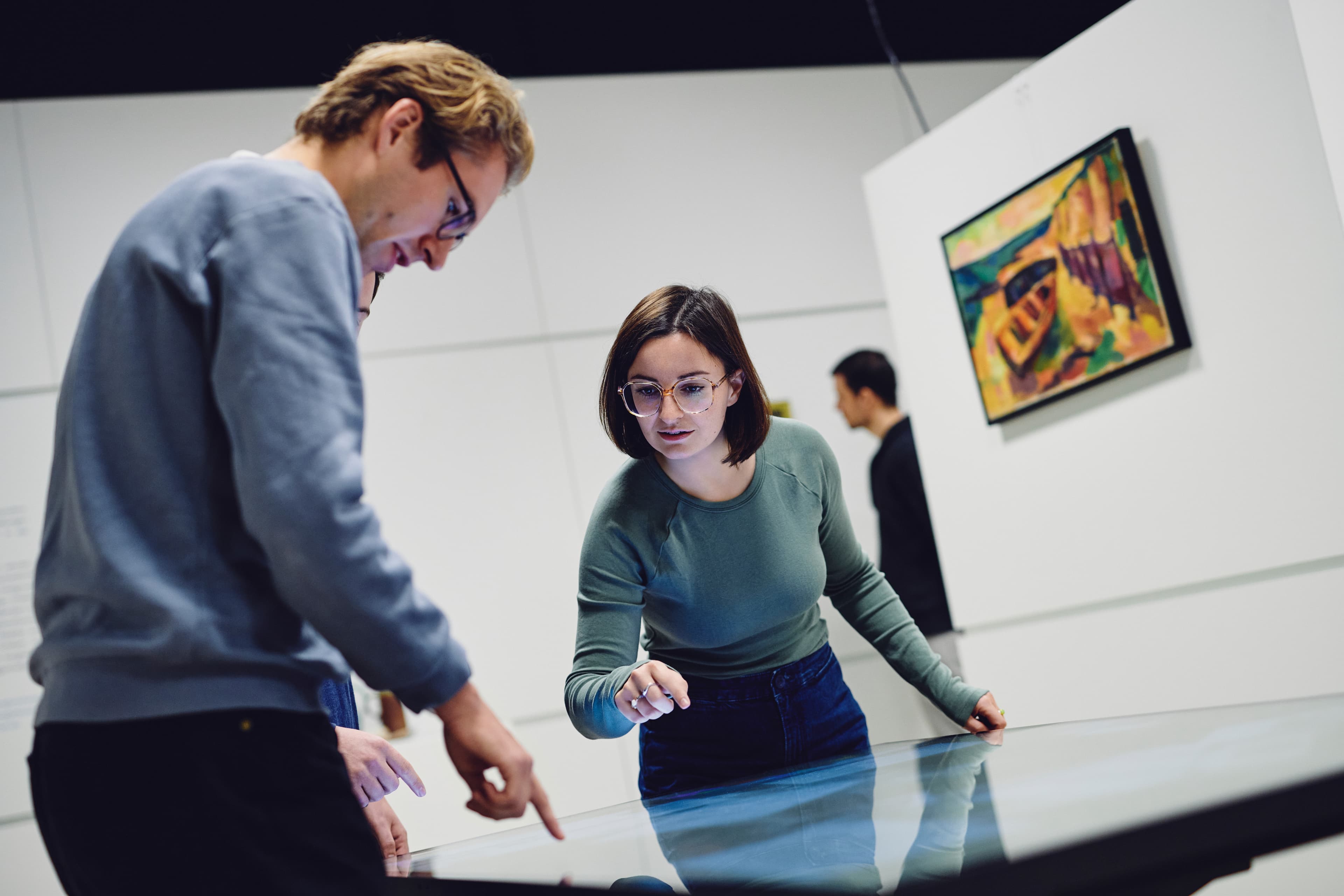 Im Vordergrund zwei Versuchspersonen an einem Multi-Touch-Tisch