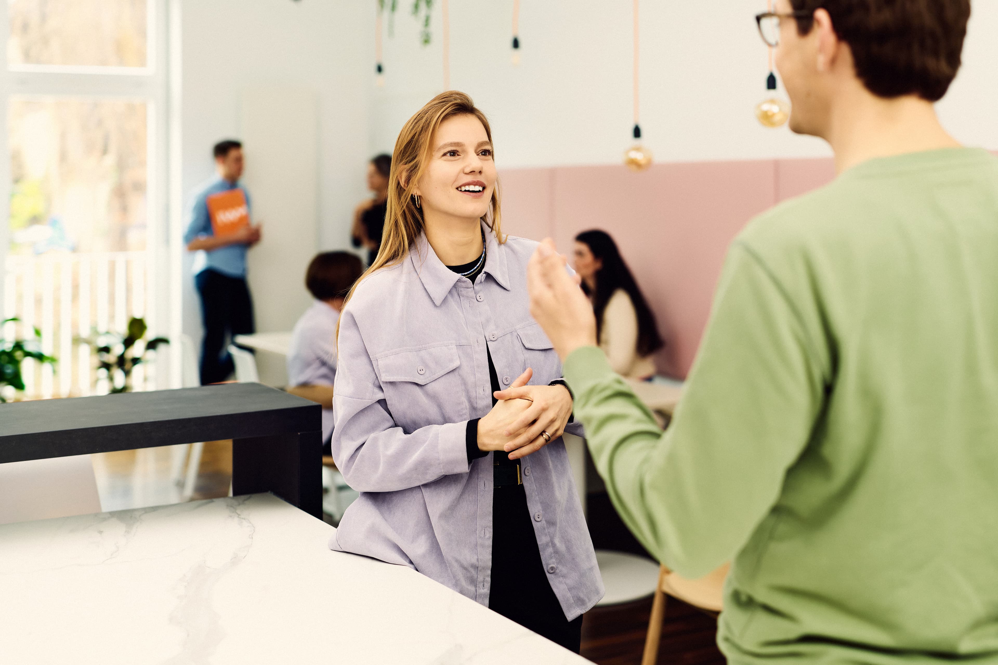 Two IWM employees talking at the counter of the work café