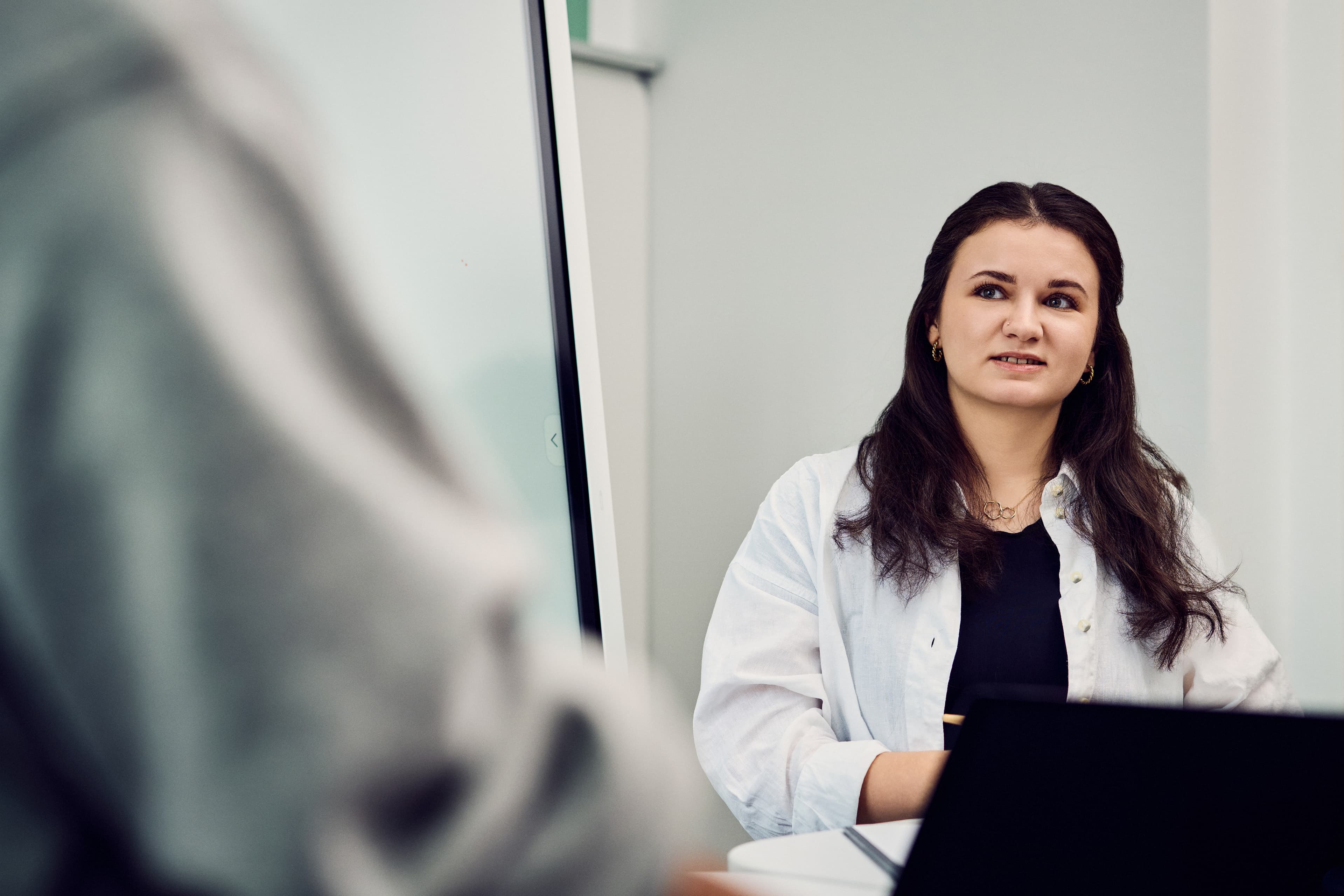 An IWM employee with laptop in dialogue with a colleague