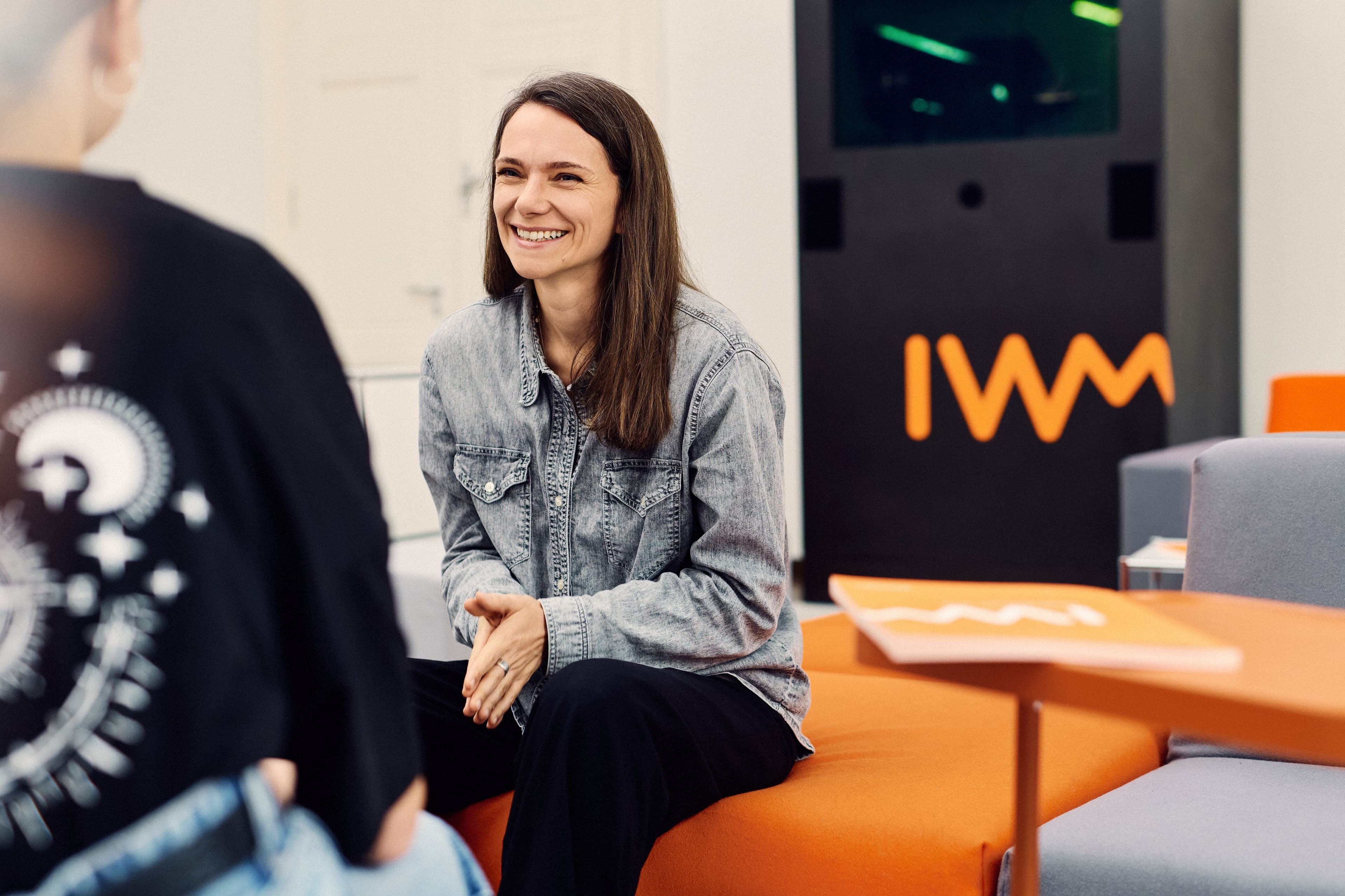 An IWM employee chatting with a colleague in the foyer