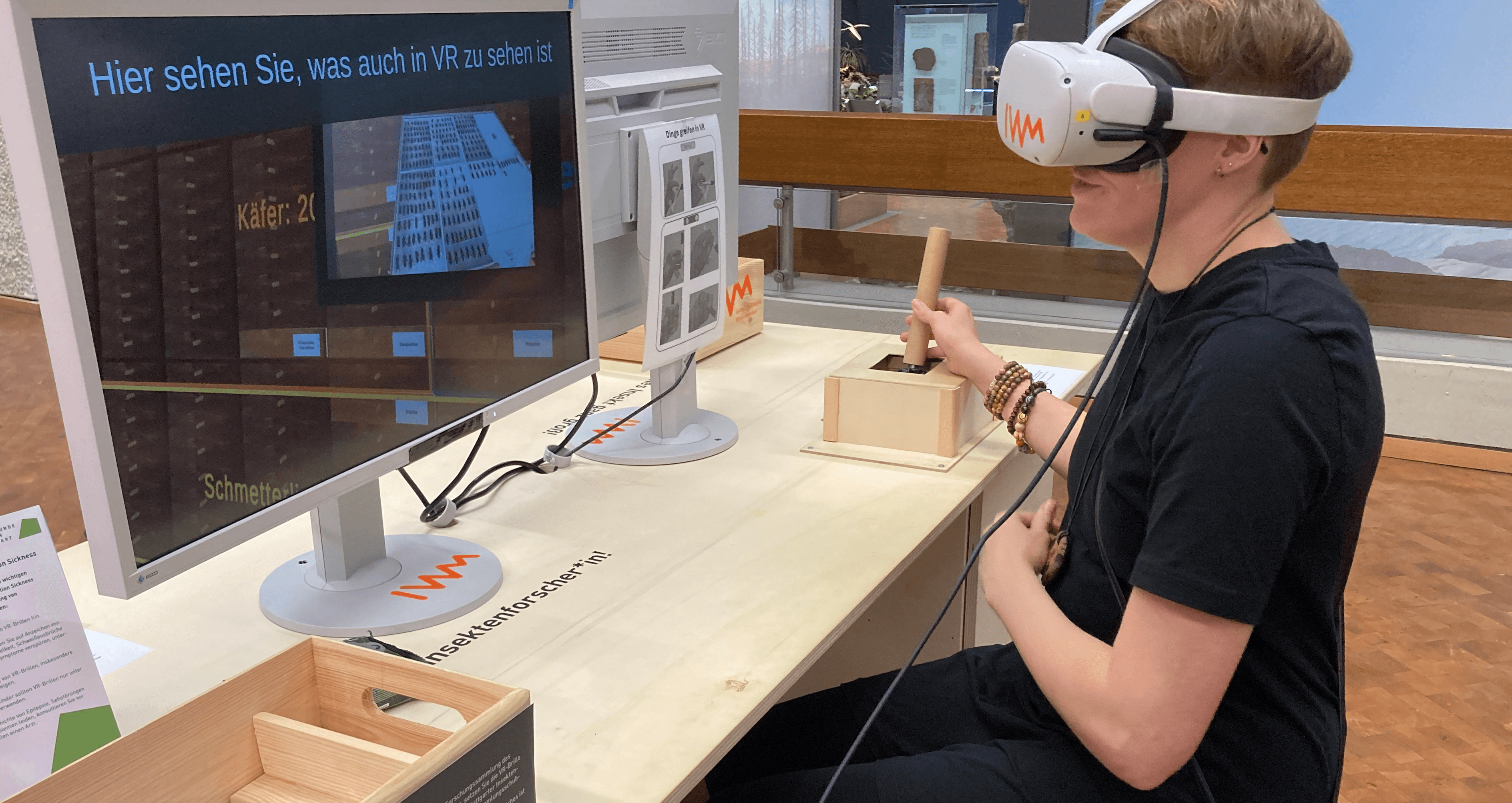 Person wearing VR glasses in front of a screen