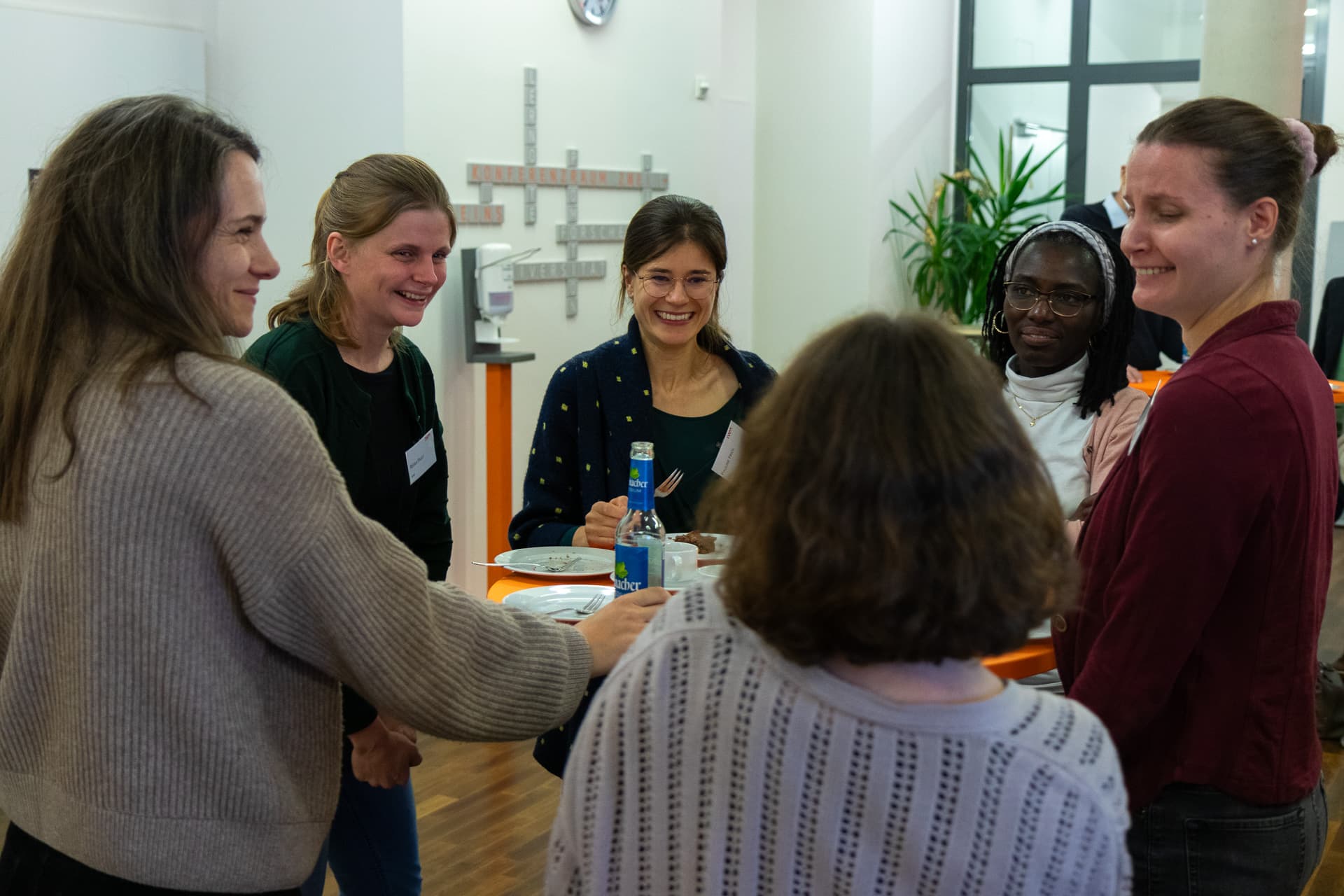 Six IWM alumni in conversation at a high table