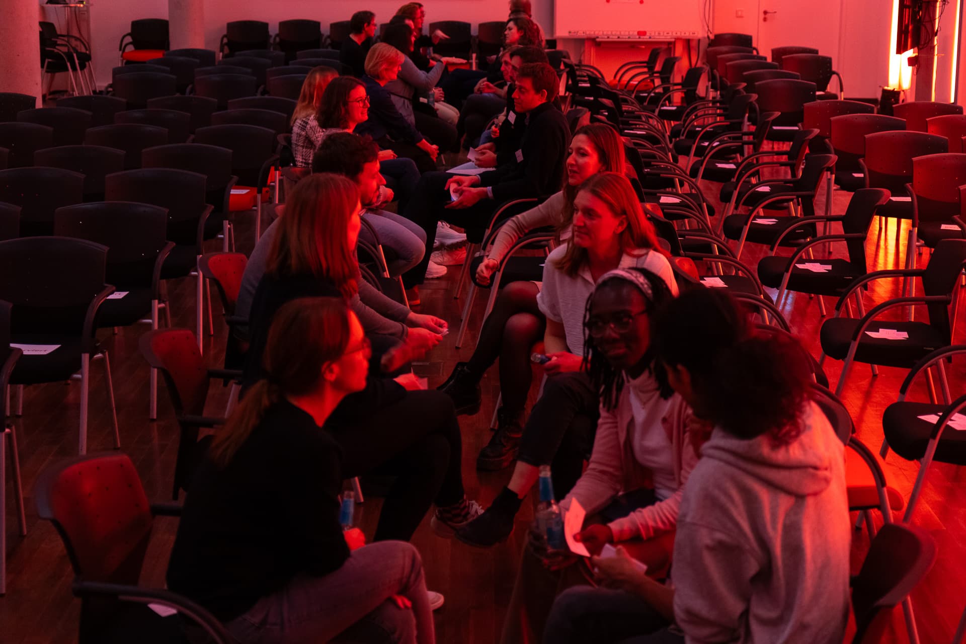 ‘Speed dating’ of alumni in a reddish-orange illuminated room