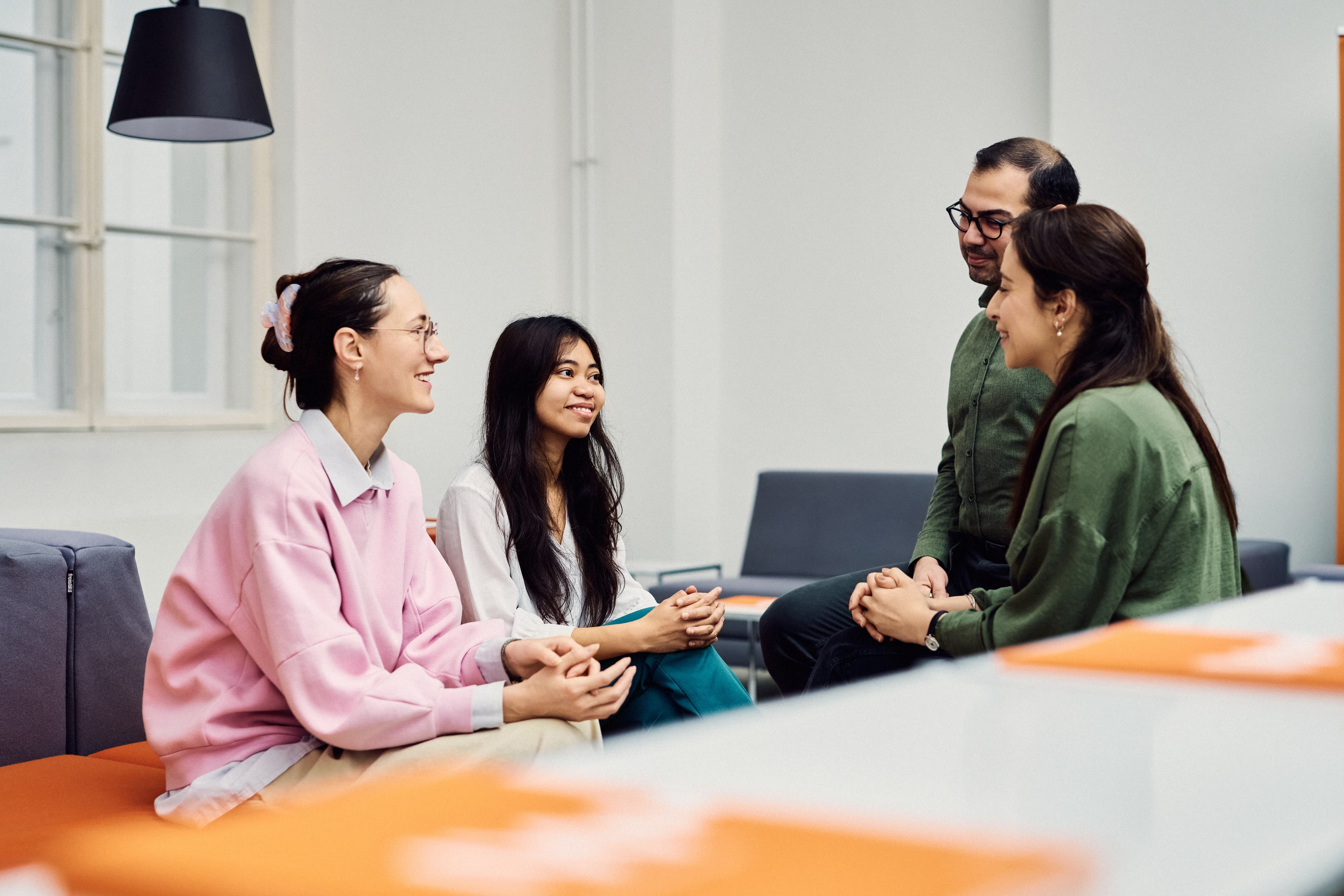 Vier IWM-Mitarbeitende sitzen zusammen und unterhalten sich