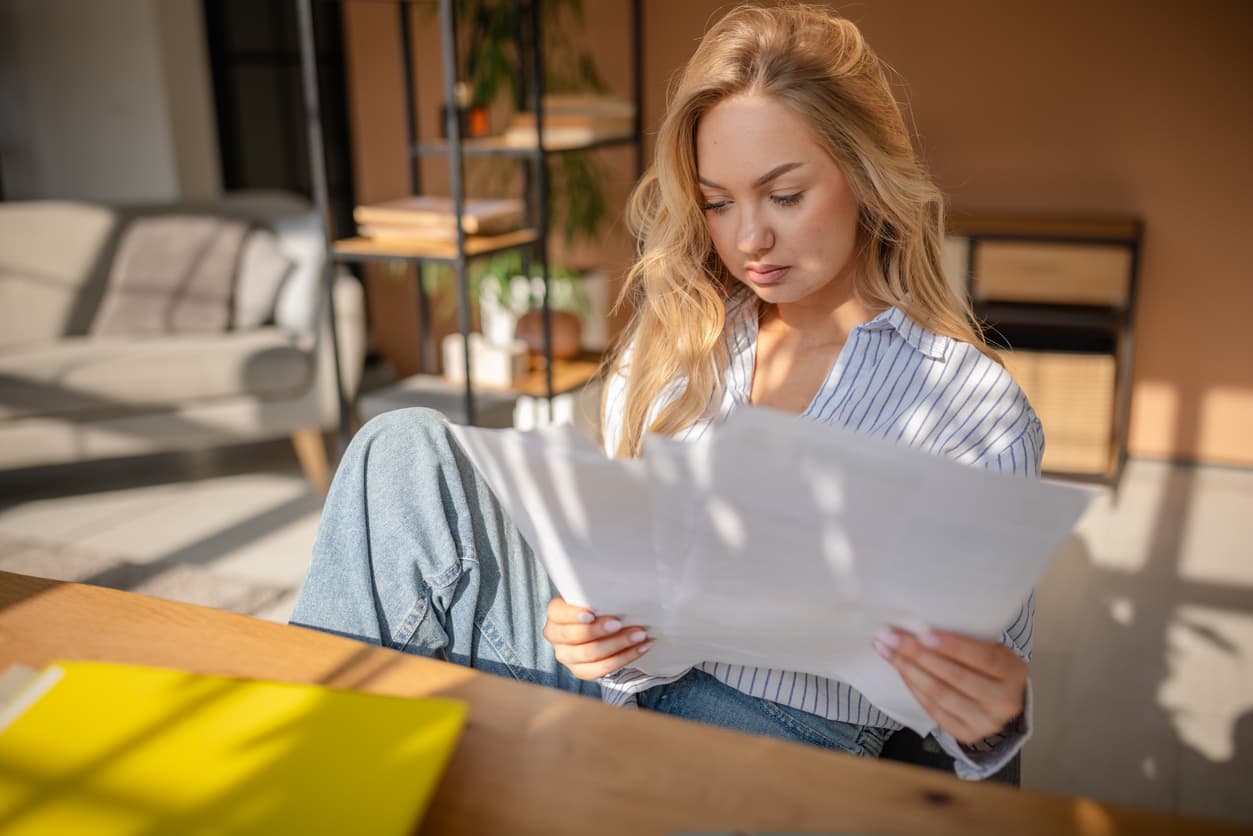 A woman sitting at a desk looking at documents